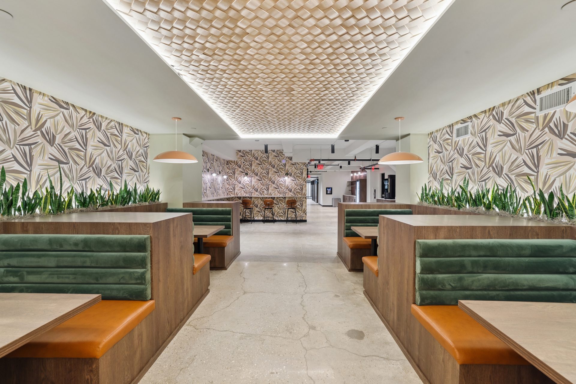 The NYC Space lounge — warm wood booths, kitchen and bar beyond