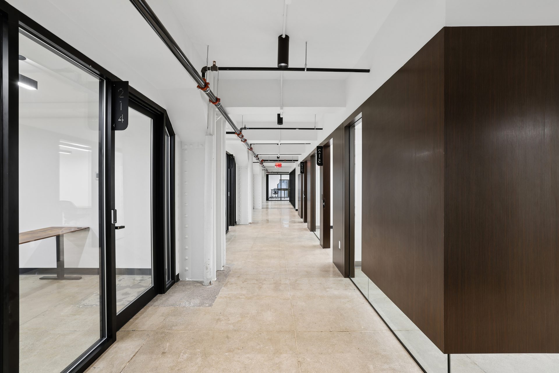 A corridor of private, glass-walled offices